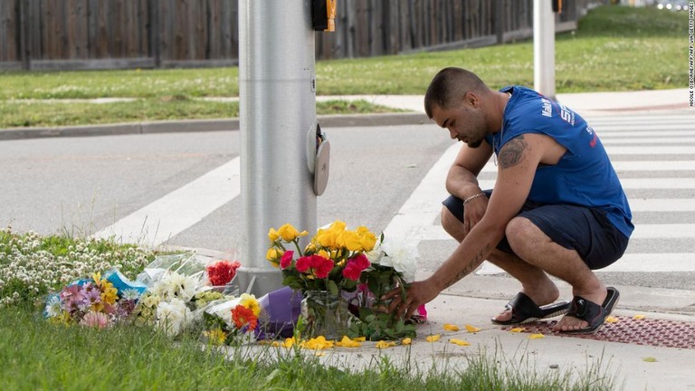 ５人家族に車が突っ込んだ現場に花を供える男性/NICOLE OSBORNE/AFP/AFP via Getty Images