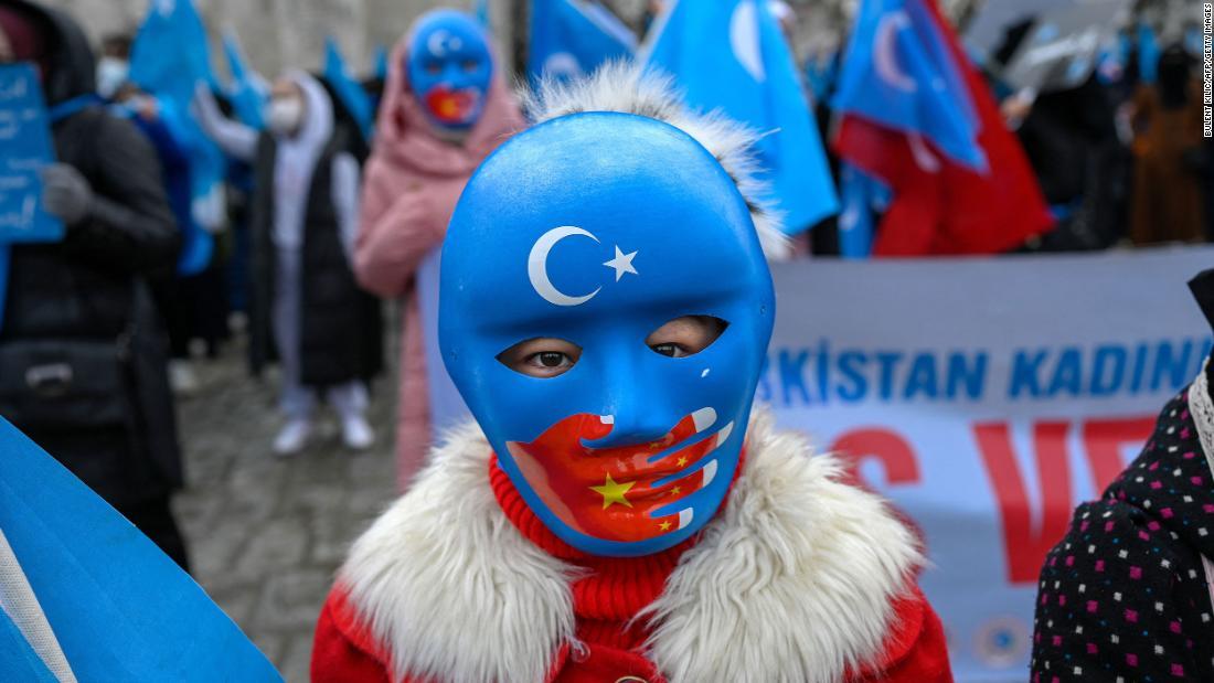 トルコのウイグル族コミュニティーの子どもが仮面をつけて中国外相のトルコ訪問に抗議=21年3月25日/Bulent Kilic/AFP/Getty Images