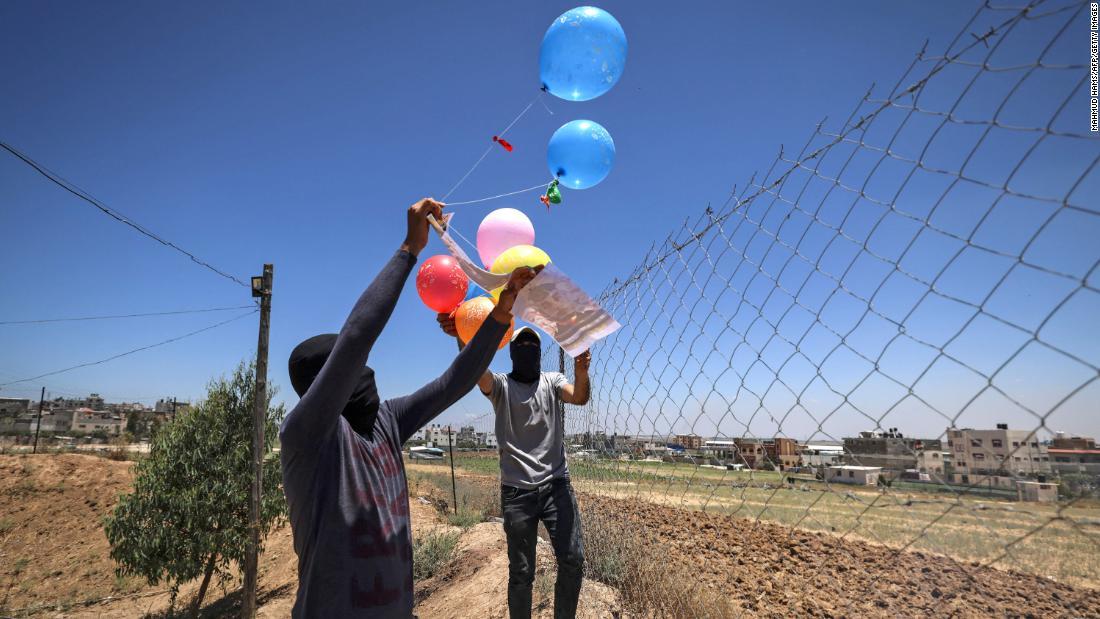 覆面をした「イスラム・ジハード」の支持者が風船爆弾を飛ばす＝１５日/Mahmud Hams/AFP/Getty Images