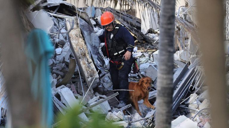 救助隊ががれきの中を捜索/David Santiago/Miami Herald/AP
