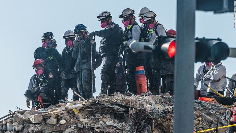 崩壊した集合住宅のがれきの中から捜索を行う救助隊ら＝２８日/Giorgio Viera/AFP/Getty Images