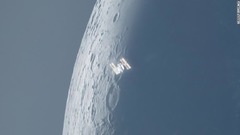 ２台のカメラと２台の望遠鏡を使って撮影された写真。日中、国際宇宙ステーションが非常に細い姿の月の前を横切る