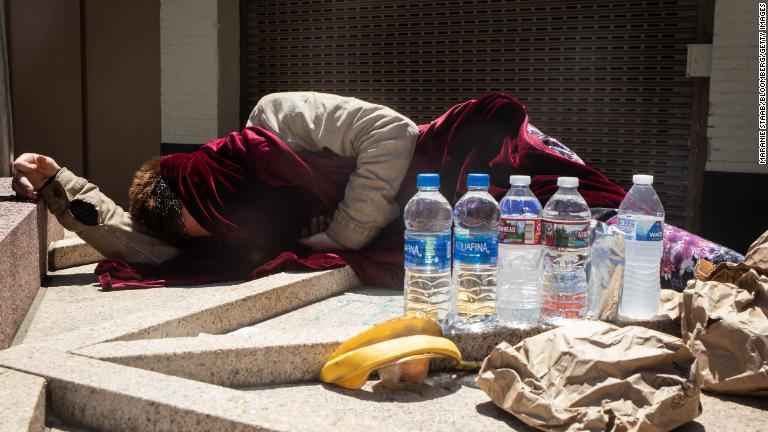 路上に寝転ぶホームレスの男性。非営利団体が涼をとれる施設をオレゴン州の各地で開設している/Maranie Staab/Bloomberg/Getty Images