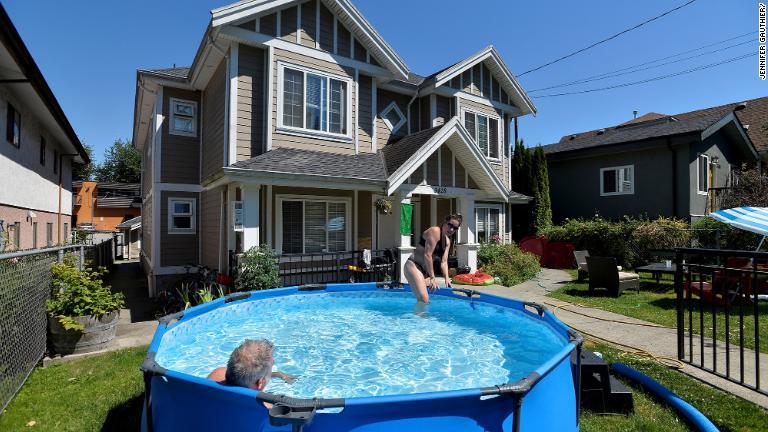 自宅の庭に設置されたプールを利用するカップル＝カナダ・バンクーバー/Jennifer Gauthier/Reuters