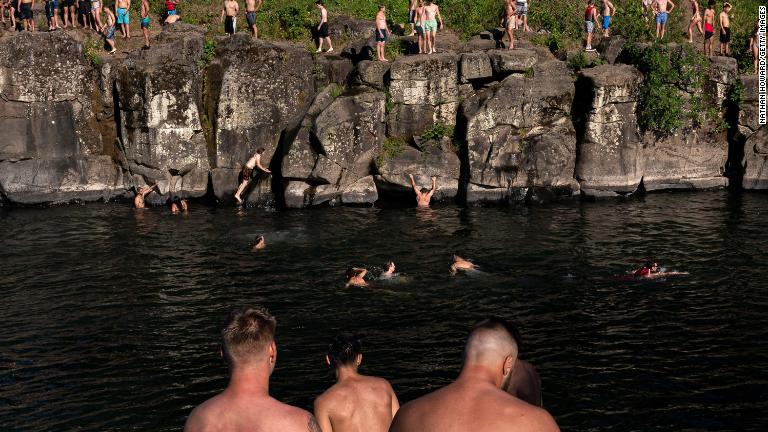 川に飛び込む人々＝オレゴン州ポートランド/Nathan Howard/Getty Images