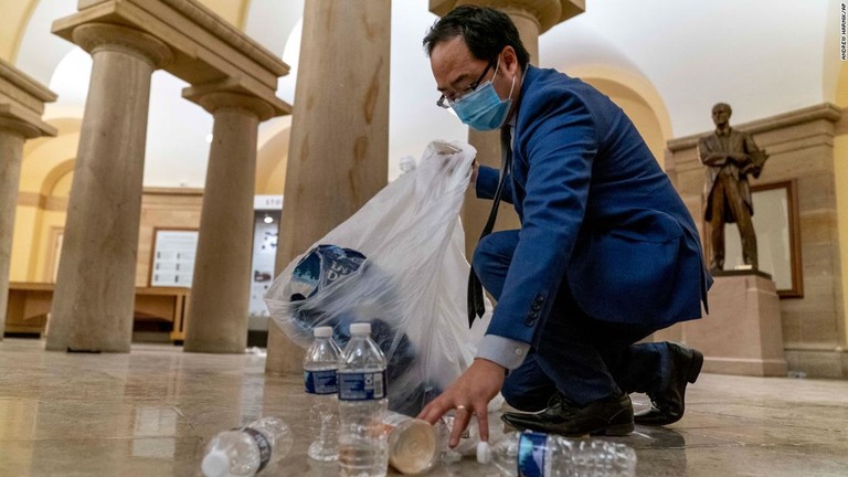 １月７日の早朝に床のゴミを片付ける米民主党のアンディ・キム下院議員/Andrew Harnik/AP