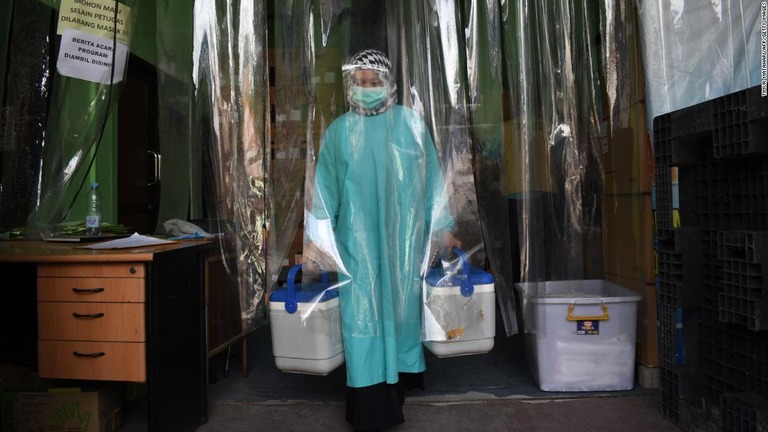 シノバック製ワクチンのケースを冷蔵室から運ぶ医療従事者＝インドネシア/Timur Matahari/AFP/Getty Images