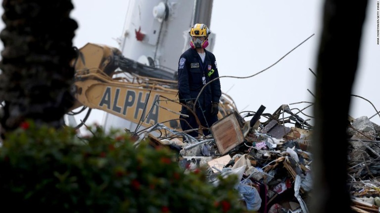 集合住宅の崩落現場でがれきの上に立つ作業員＝１０日/Anna Moneymaker/Getty Images