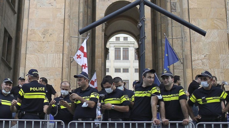 報道カメラマンの死後、議会外で行われた集会を見守る警官/David Mdzinarishvili/TASS/Getty Images