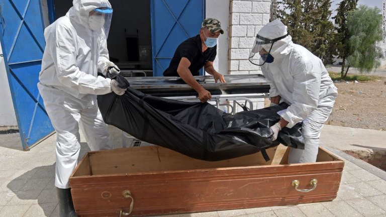 新型コロナ患者の遺体をひつぎに入れる職員＝４日、チュニジアの都市ケルアンの病院/Fethi Belaid/AFP/Getty Images