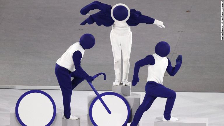 トライアスロンのピクトグラム(絵文字)を表現するパフォーマー/Sergei Bobylev/TASS/Getty Images