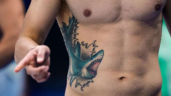 色鮮やかなサメのタトゥーを入れて五輪のトレーニングセッションに参加する競泳選手/Martin Meissner/AP