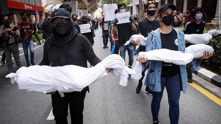 コロナ死者の遺体に見立てた布を手にクアラルンプールでデモ行進する人々/Wong Fok Loy/SOPA Images/Getty Images
