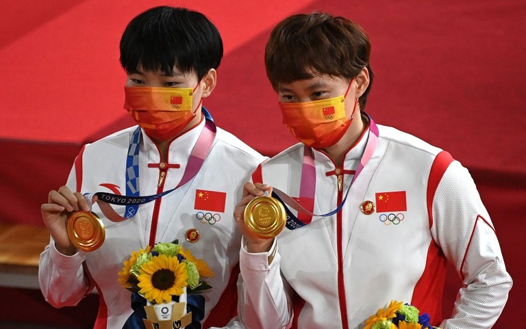 五輪の自転車種目を制した中国選手２人が毛沢東のバッジを着けて表彰台に上がった/Greg Baker/AFP/Getty Images