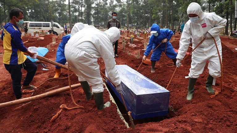 防護具を着けてコロナ死者の棺を埋葬するインドネシア・西ジャワ州の作業員/Achmad Ibrahim/AP
