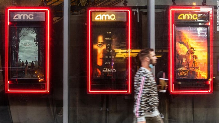 ニューヨーク市内のＡＭＣ映画館のポスター前を通り過ぎる人/Jeenah Moon/Bloomberg/Getty Images