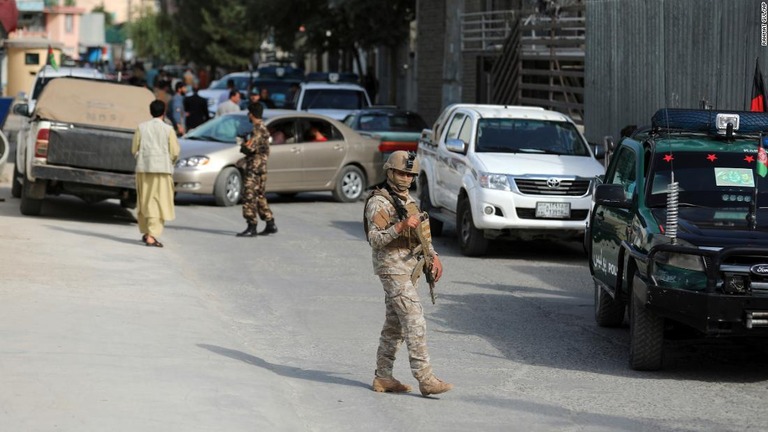 アフガン政府の情報メディアセンター長がタリバーンに射殺された現場を歩く治安部隊＝６日、カブール/Rahmat Gul/AP