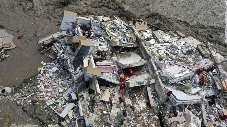 洪水によって倒壊した建物で救助活動を行う人々＝１２日、トルコ・カスタモヌ/Bilal Kahyaoglu/Anadolu Agency via Getty Images