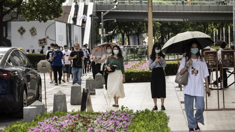 朝のラッシュ時、上海の金融街をマスク姿で歩く人々/Qilai Shen/Bloomberg/Getty Images
