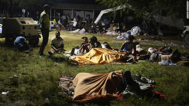 家から逃れ病院前で夜を明かす住民=14日、レカイ/Joseph Odelyn/AP