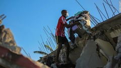 地震で壊れた自宅から私物を運ぶ男性＝１４日