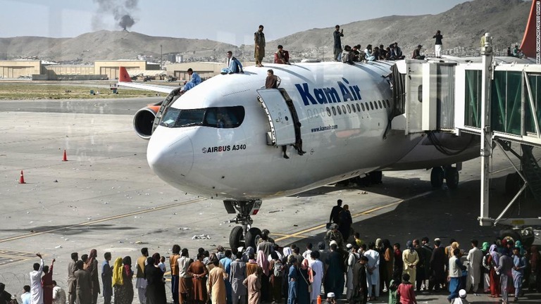 アフガニスタンからの脱出を希望する人々がカブールの空港を離陸する航空機に殺到した/Wakil Kohsar/AFP/Getty Images
