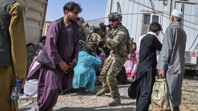 空港でアフガニスタンの乗客に銃を向ける米軍兵士＝１６日、アフガニスタン・カブール/Wakil Kohsar/AFP/Getty Images