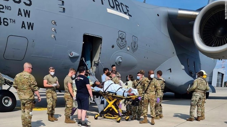 輸送機から搬送される出産後の母親と家族ら（画像の一部を加工しています）/U.S. Air Force/Reuters