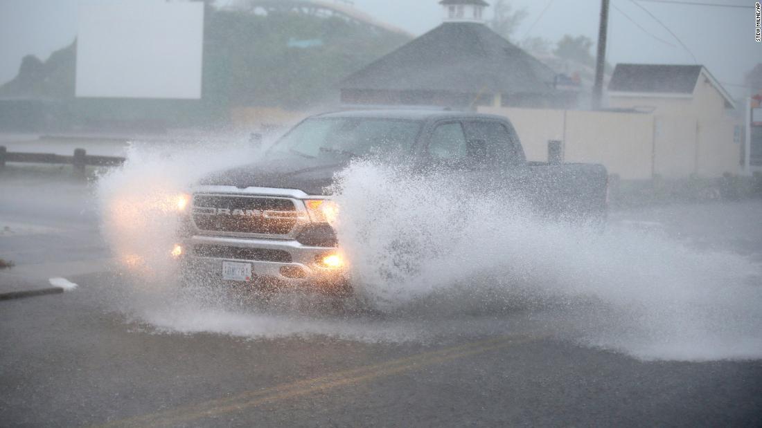 米ロードアイランド州ウェスタリーで冠水した道路を走る車＝２２日/Stew Milne/AP