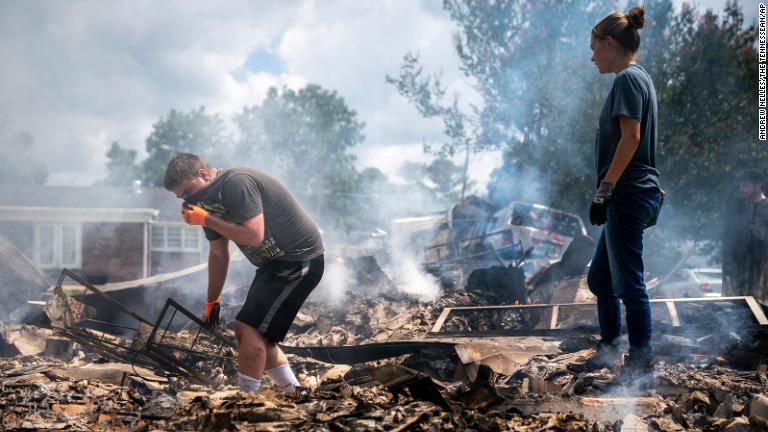 洪水の後に焼け落ちた自宅から何か物が残っていないか探す人々＝ウェーバリー/Andrew Nelles/The Tennessean/AP