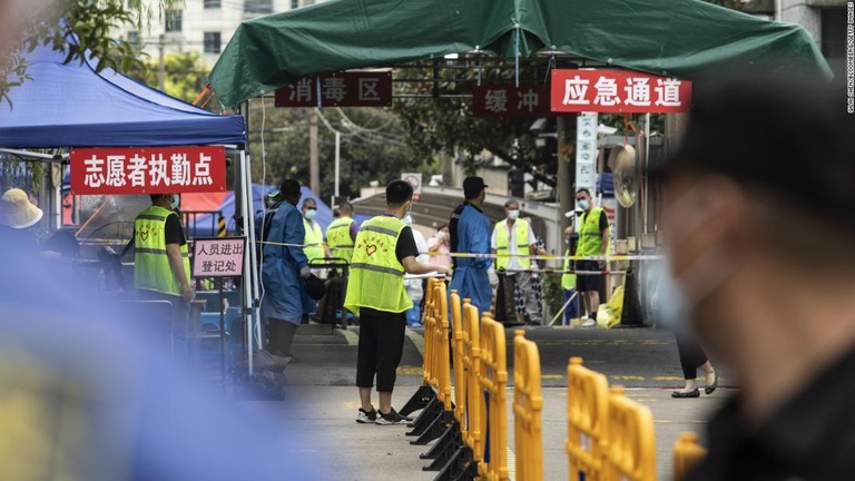 警察などが上海で封鎖中の地区の入り口に立つ＝２１日/Qilai Shen/Bloomberg/Getty Images