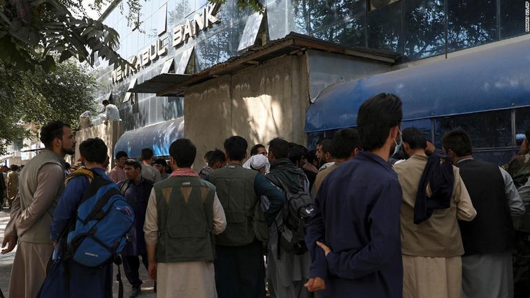 首都カブールの銀行の前で長時間にわたり預金引き出しの順番待ちをするアフガン人/Rahmat Gul/AP