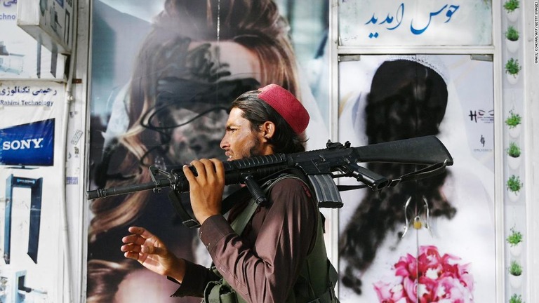 美容サロンの前を通るタリバン戦闘員/Wakil Kohsar/AFP/Getty Images