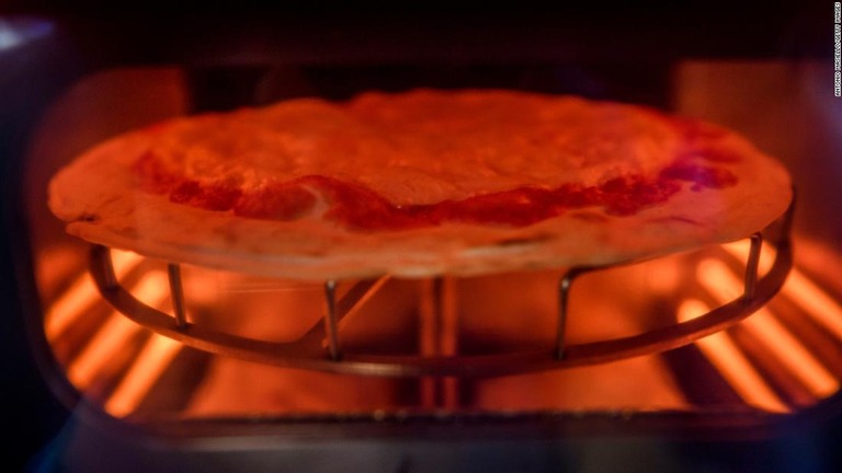 自販機内の小さなオーブンで焼き上げられるピザ/Antonio Masiello/Getty Images