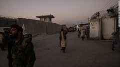 爆発事件後に空港付近の道路を守るタリバンのメンバー＝２６日