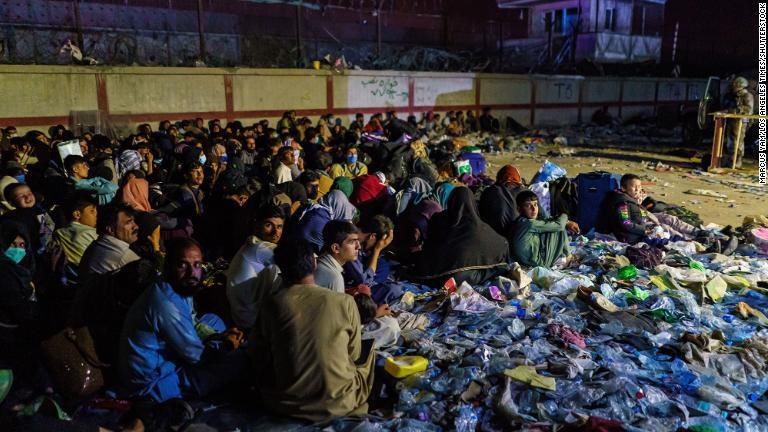バロンホテル前に集まるアフガン人の避難民。英国軍が周囲を守る＝２６日/Marcus Yam/Los Angeles Times/Shutterstock