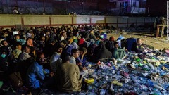 バロンホテル前に集まるアフガン人の避難民。英国軍が周囲を守る＝２６日