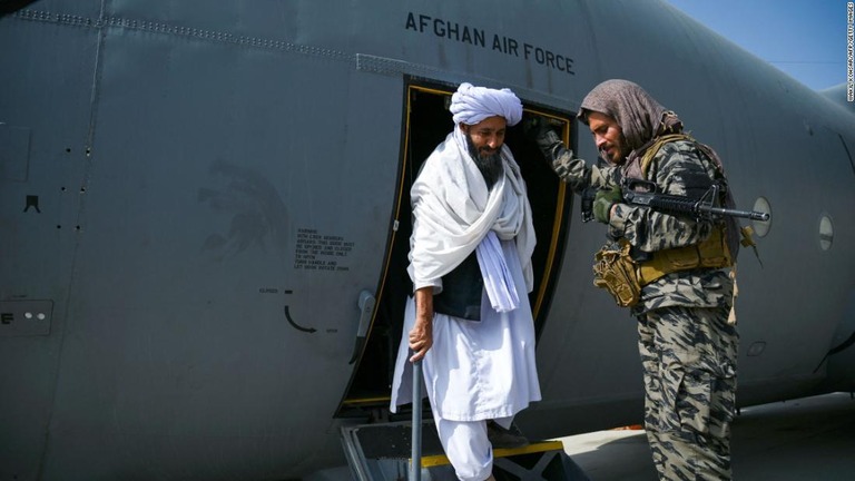 アフガニスタン空軍の航空機から降りるタリバンのメンバー＝８月３１日、カブールの空港/Wakil Kohsar/AFP/Getty Images