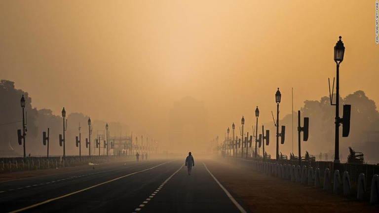 スモッグでかすむ街中を歩く男性＝２０２１年１月、インド首都ニューデリー/Jewel Samad/AFP/Getty Images