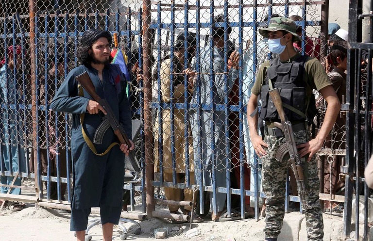 国境で互いの領土を警備するアフガニスタンのタリバン兵士（左）とパキスタンの民兵/Muhammad Sajjad/AP