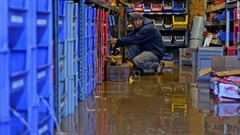 商店に浸水し後片付けに追われる従業員＝２日、ニュージャージー州ウッドランドパーク