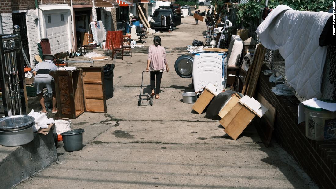 浸水した自宅の清掃を行う人々＝３日、米ニューヨーク市クイーンズ地区/Spencer Platt/Getty Images