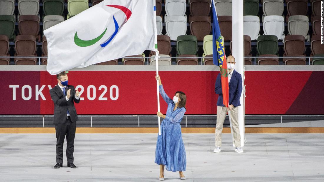 引き継がれたパラリンピック旗を振るパリのイダルゴ市長（中央）/Charly Triballeau/AFP/Getty Images