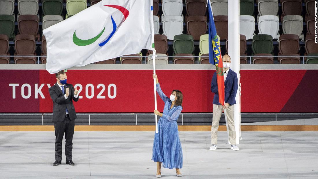引き継がれたパラリンピック旗を振るパリのイダルゴ市長(中央)/Charly Triballeau/AFP/Getty Images