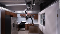 トヨタ・リサーチ・インスティテュート（ＴＲＩ）はカリフォルニア州の研究所で、人間を補助するロボットを開発している。写真の「ガントリーロボット」は天井からコウモリのようにぶら下がることで、床のスペースを節約できる