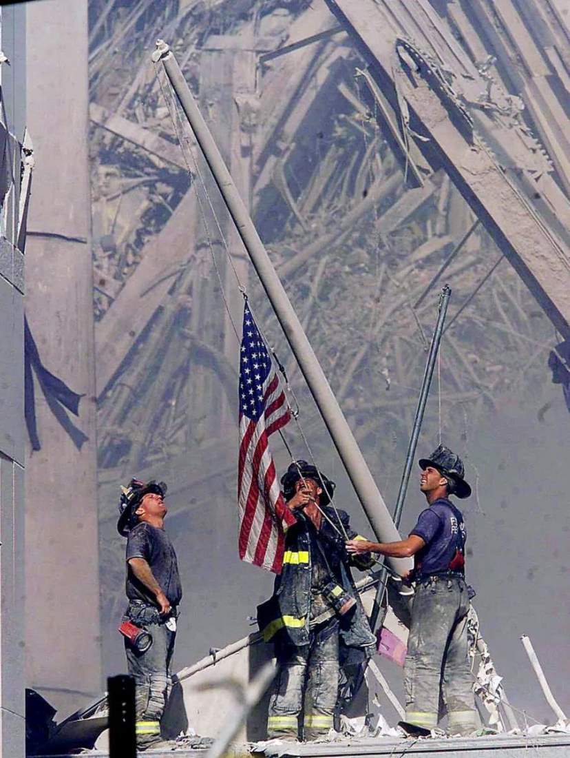 世界貿易センタービルの崩落現場で米国旗を掲げる消防士のジョージ・ジョンソン氏、ダン・マクウィリアムズ氏、ビリー・アイゼングレイン氏/Thomas E. Franklin/The Bergen Record/AP