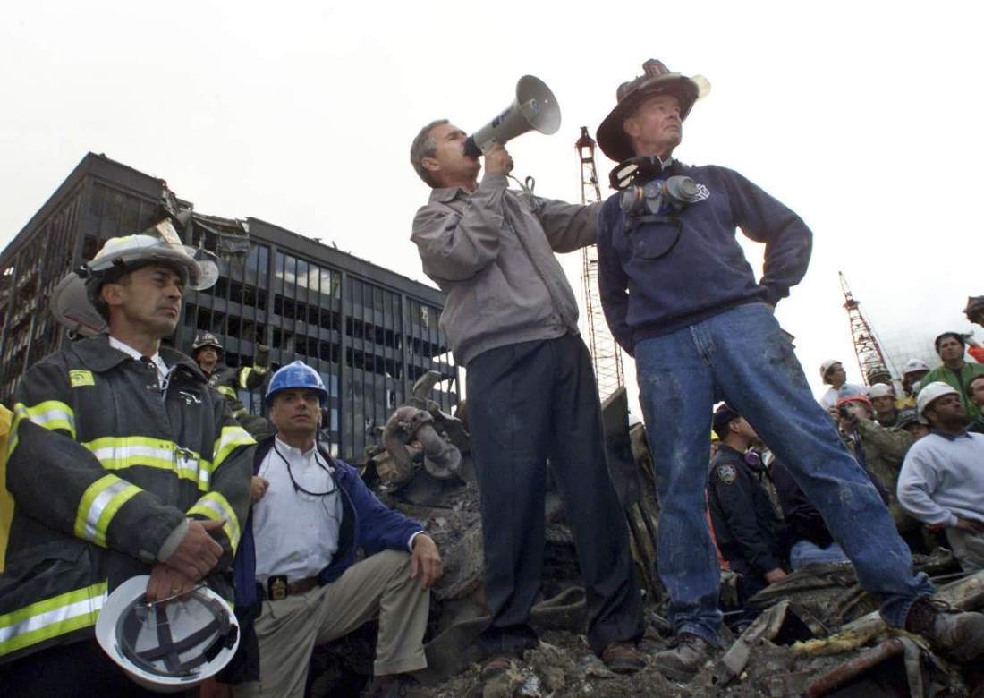 同時多発テロから３日後、ニューヨークの世界貿易センタービルの崩落現場「グラウンド・ゼロ」のがれきの中で働く救助隊員、消防士、警察官に話しかけるブッシュ大統領。写真を撮影したウィン・マックナミー氏は「一番覚えているのは現場の音とにおい、最高レベルの警備、現場で働く最前線の人々とブッシュ大統領がつながろうとした方法だった」と語る/Win McNamee/Reuters