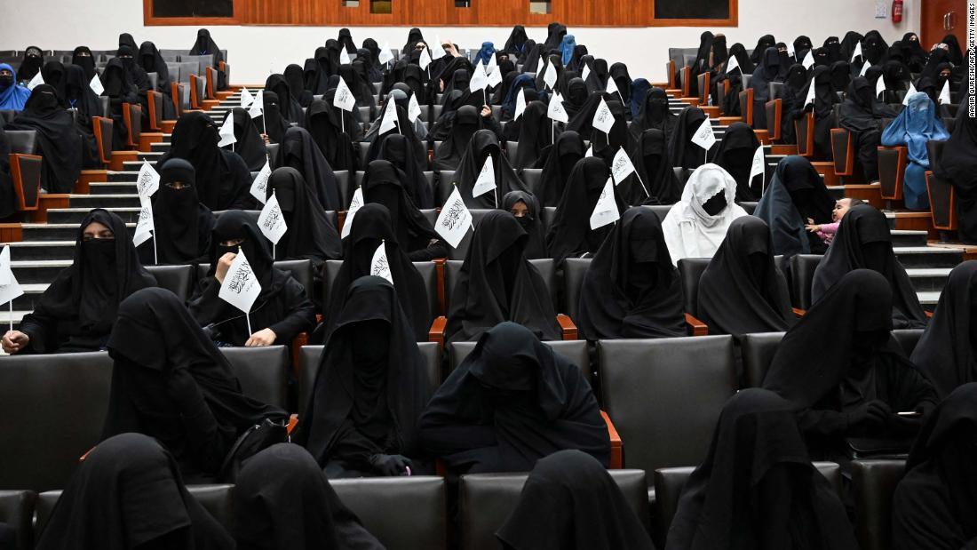 大学内の集会で黒い衣服を身につけてタリバンの旗を振る女子学生＝１１日、アフガニスタン首都カブール/AAMIR QURESHI/AFP/Getty Images