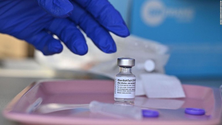ファイザー製の新型コロナウイルスワクチンに手を伸ばそうとする医療関係者＝８月２３日、米ロサンゼルスの接種会場/Robyn Beck/AFP/Getty Images