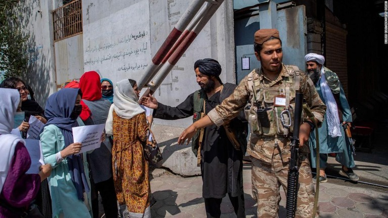 女性問題省があった建物前をデモ行進する女性がタリバーンの兵士と会話＝１９日、カブール/BULENT KILIC/AFP/Getty Images